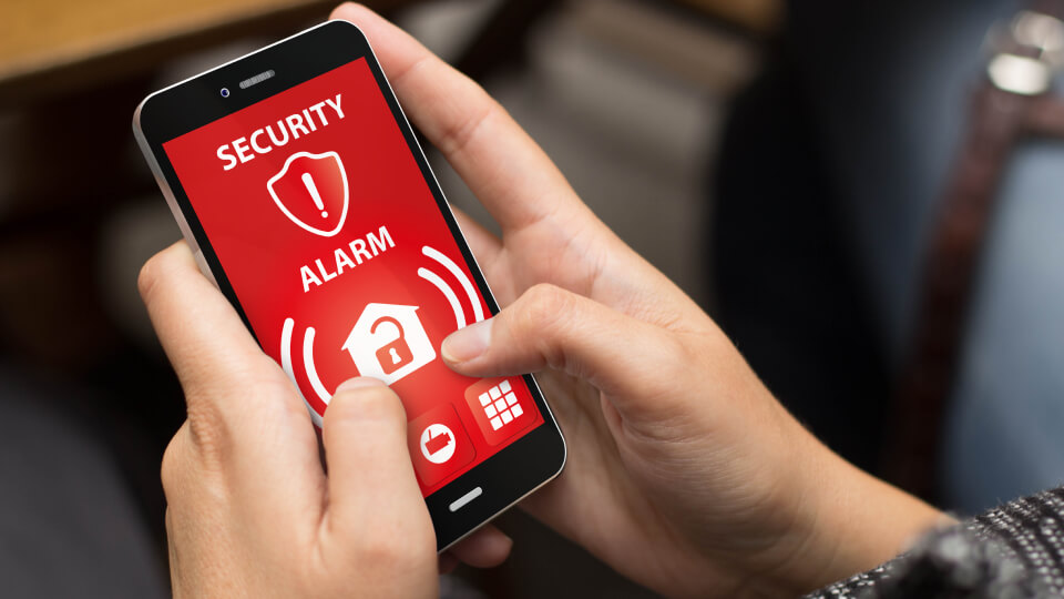 Commercial security alarm system showing alarm warning on a mobile phone as part of a business security alarm system